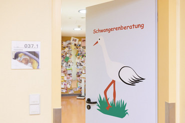 Storch auf der Eingangstür zur Schwangerenberatung an der Klinik für Gynäkologie und Geburtshilfe